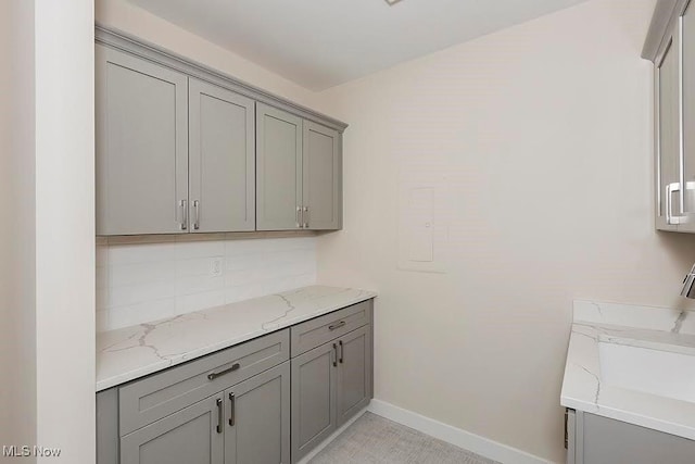 27500 Cedar Rd Unit 804, Beachwood, OH 44122 - kitchen with gray cabinetry, baseboards, and light stone countertops