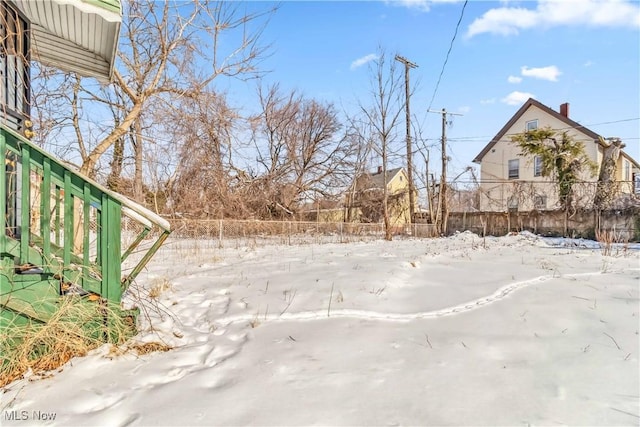 yard covered in snow with fence