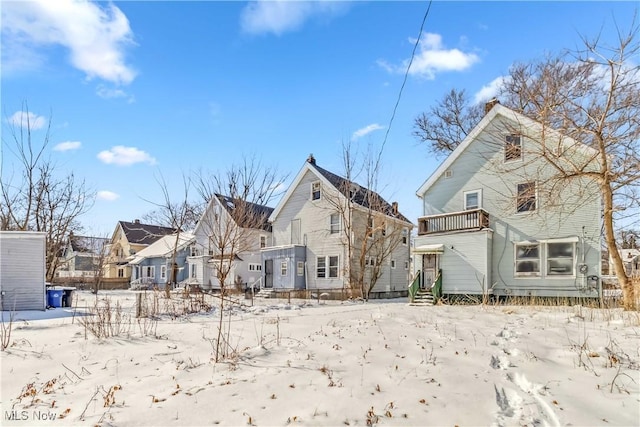 snow covered house featuring a residential view