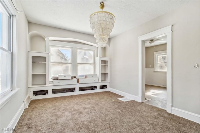 interior space with a notable chandelier, baseboards, and carpet floors