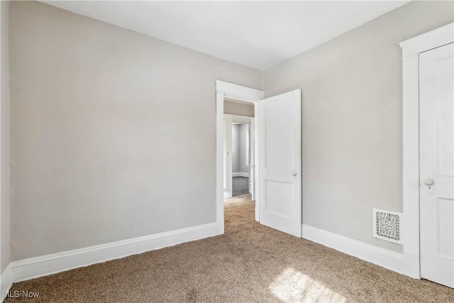 unfurnished bedroom with carpet, visible vents, and baseboards