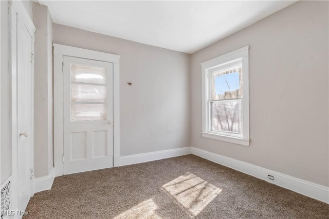 carpeted spare room featuring baseboards