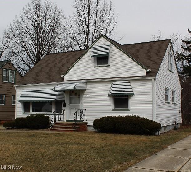 bungalow-style home featuring a front yard and a shingled roof