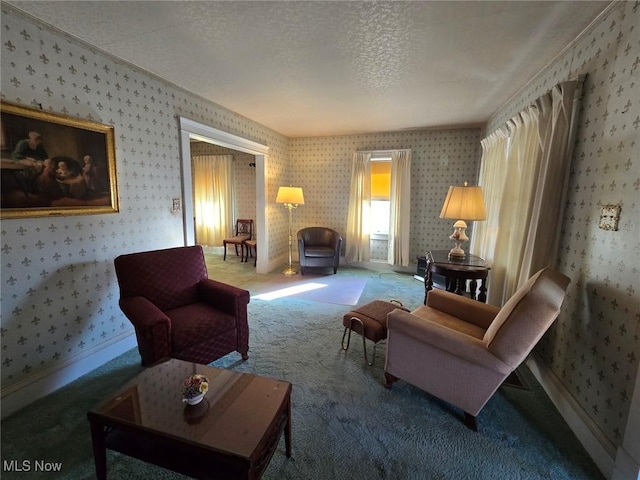 sitting room with baseboards, a textured ceiling, carpet, and wallpapered walls