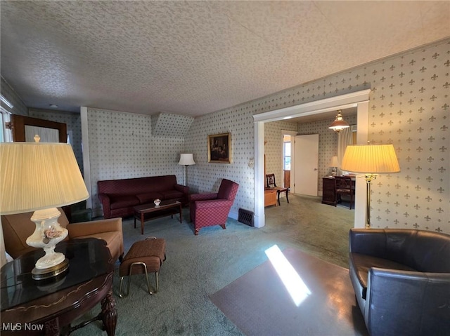 carpeted living area featuring a textured ceiling and wallpapered walls