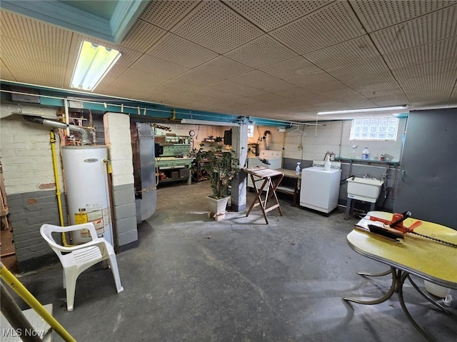 basement with gas water heater, a workshop area, washer / dryer, and a sink