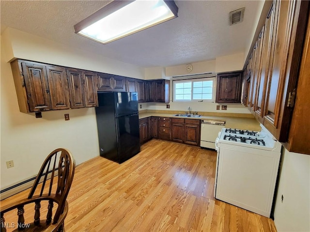 kitchen with a sink, range with gas stovetop, freestanding refrigerator, light wood-style floors, and dishwasher