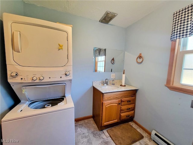 bathroom with visible vents, stacked washer and clothes dryer, baseboards, baseboard heating, and vanity