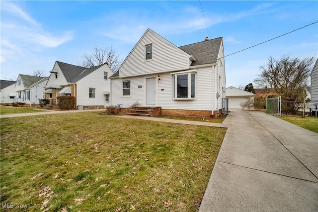 view of front of house featuring an outbuilding, a garage, and a front lawn