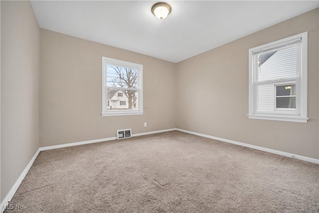 spare room featuring visible vents, baseboards, and carpet