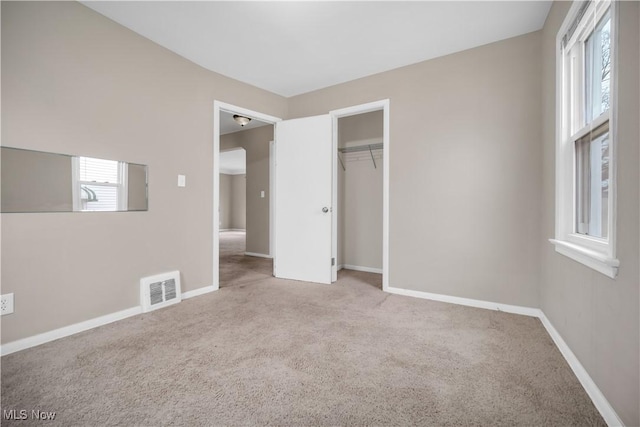 unfurnished bedroom with a closet, baseboards, visible vents, and carpet floors