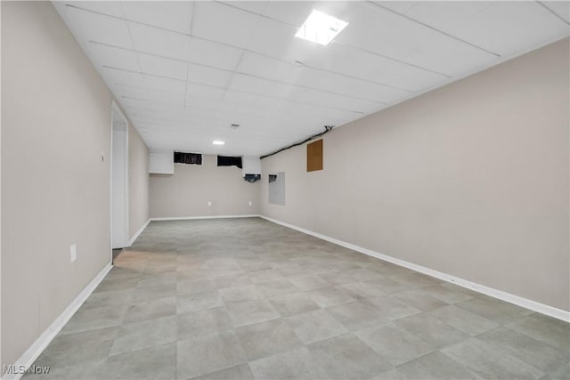 finished basement with a drop ceiling and baseboards