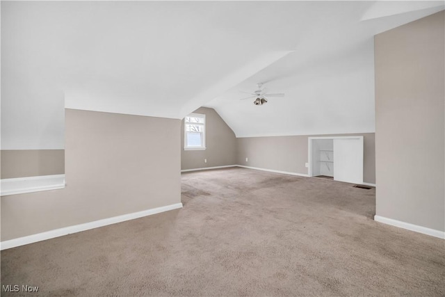 additional living space featuring baseboards, a ceiling fan, carpet, and vaulted ceiling