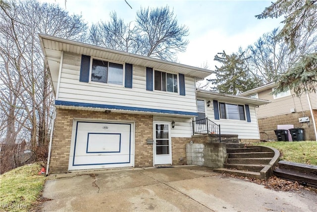 split level home featuring brick siding and concrete driveway