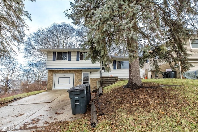 tri-level home featuring brick siding, driveway, and a garage