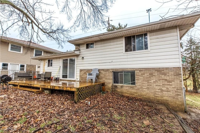 rear view of property with brick siding and a deck