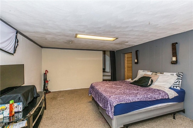 carpeted bedroom with a textured ceiling and concrete block wall