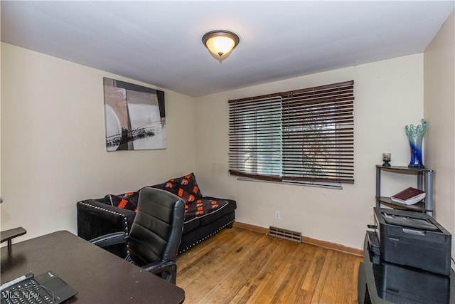 home office featuring visible vents, baseboards, and wood-type flooring