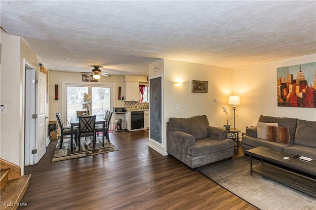 living area featuring dark wood finished floors and a textured ceiling