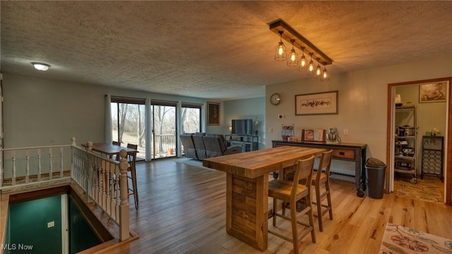 dining area featuring a textured ceiling and light wood-style floors