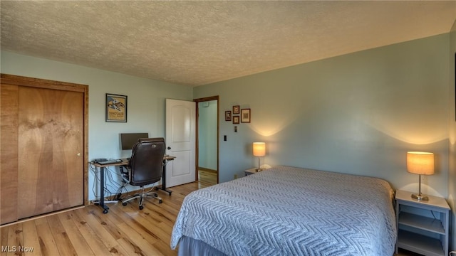 bedroom featuring light wood-type flooring and a textured ceiling