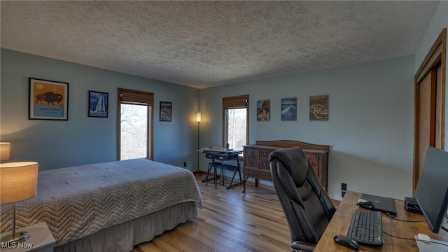 bedroom featuring wood finished floors and a textured ceiling