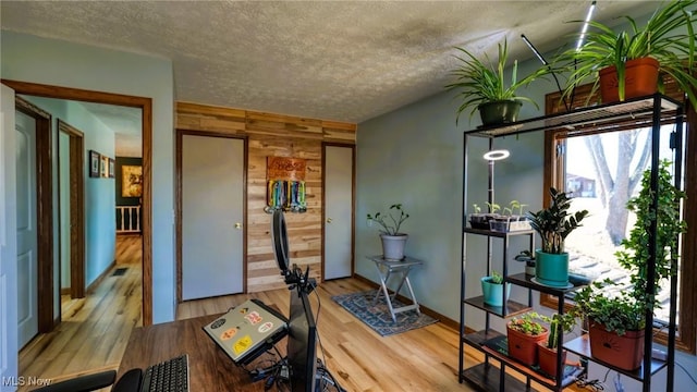 entryway featuring wood finished floors, visible vents, wood walls, and a textured ceiling