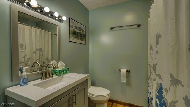 full bathroom with curtained shower, toilet, vanity, and baseboards