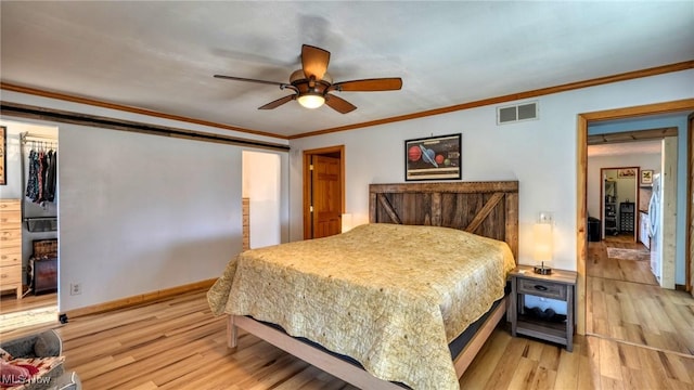 bedroom featuring visible vents, baseboards, wood finished floors, and ornamental molding