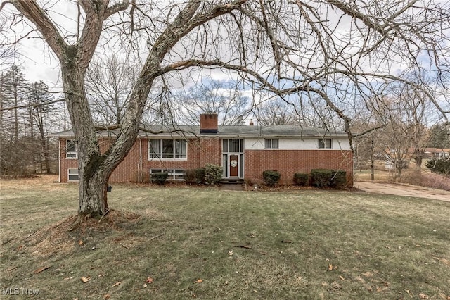 ranch-style house featuring a front yard, brick siding, and a chimney