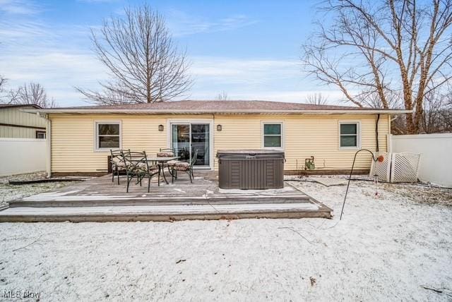 rear view of house with a wooden deck and fence