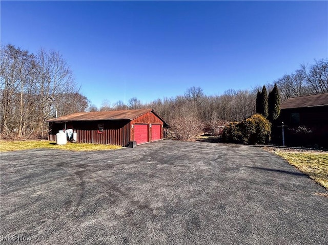 exterior space featuring aphalt driveway and an outdoor structure