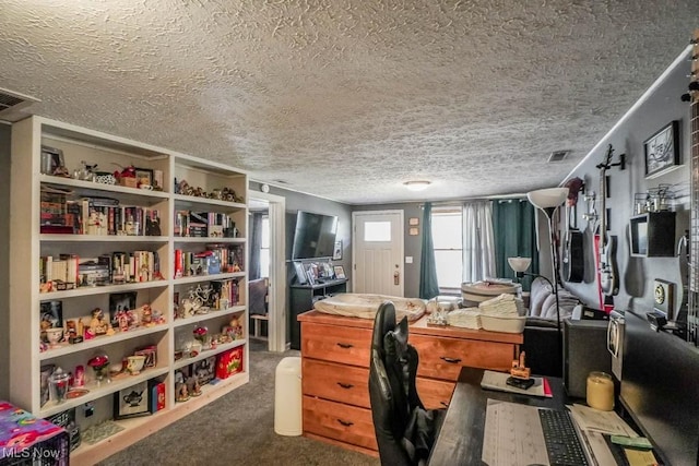 carpeted home office with visible vents and a textured ceiling
