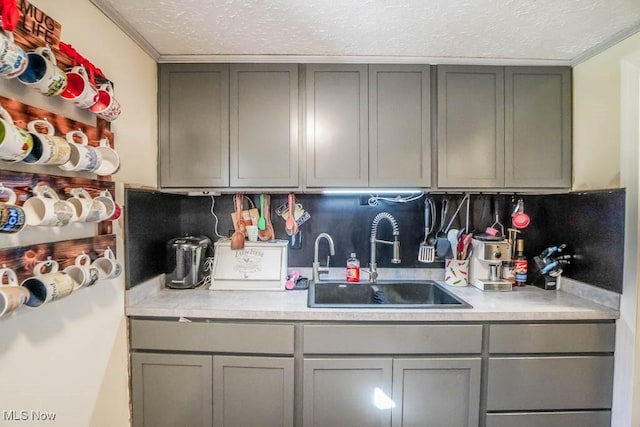 kitchen featuring gray cabinets, light countertops, and a sink