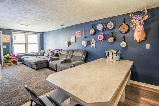 interior space with a textured ceiling, baseboards, and carpet floors