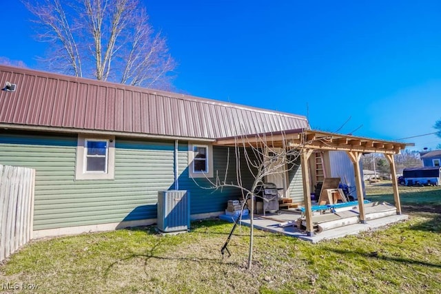rear view of house featuring a pergola, a patio, central AC, a yard, and metal roof