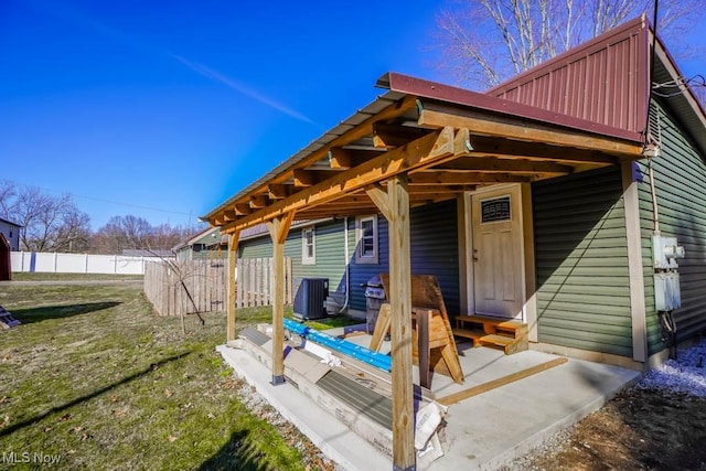 exterior space featuring cooling unit, fence, and a yard