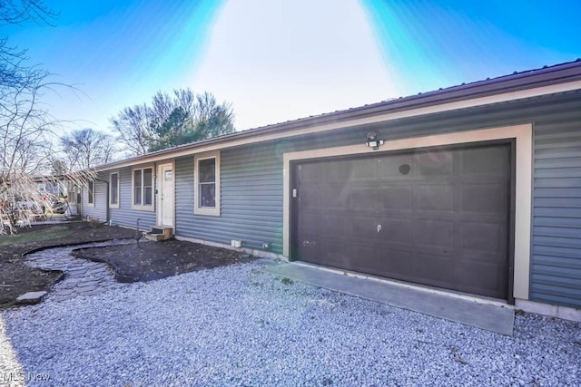 view of front of property featuring gravel driveway and a garage