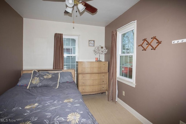 unfurnished bedroom featuring baseboards, light wood-style flooring, and a ceiling fan