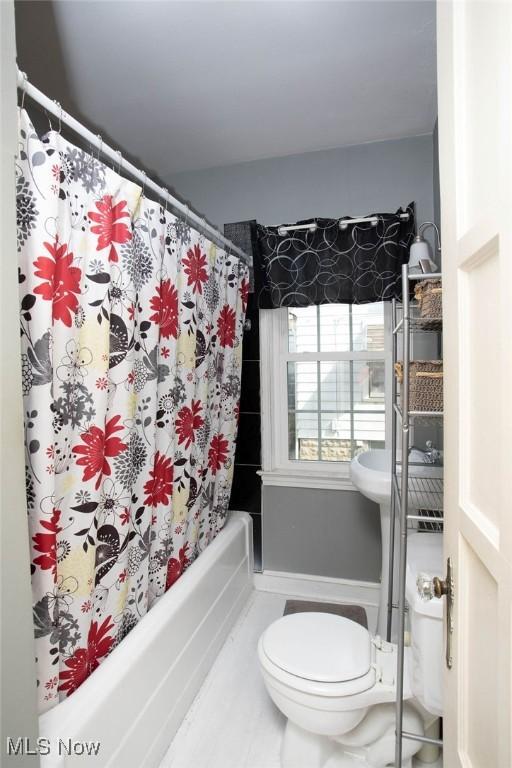 bathroom with toilet and shower / bath combo with shower curtain