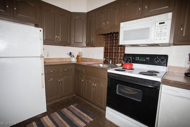 kitchen featuring dark brown cabinetry, white appliances, and a sink