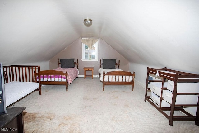 carpeted bedroom with baseboards and vaulted ceiling