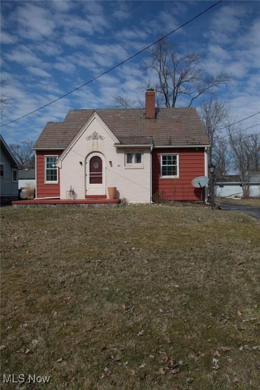 view of front facade featuring a front lawn and a chimney