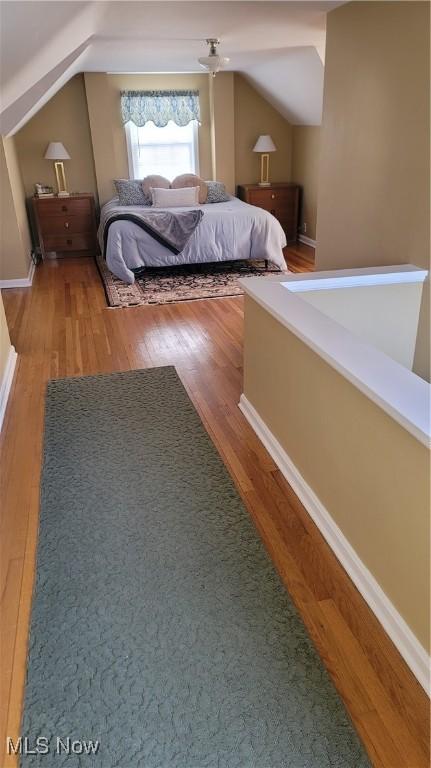 unfurnished bedroom featuring wood finished floors and vaulted ceiling