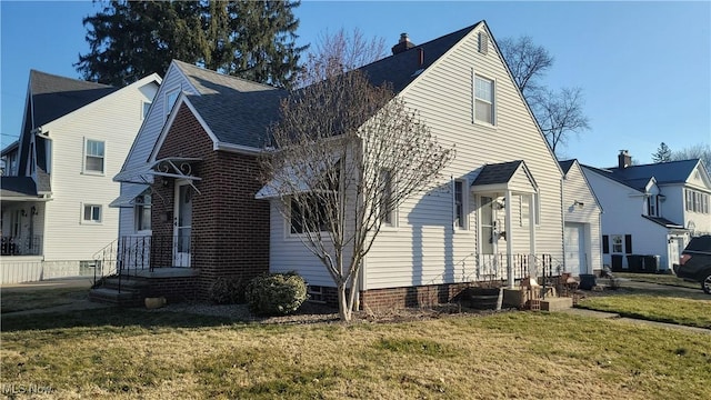 view of side of property with a lawn, a garage, and roof with shingles