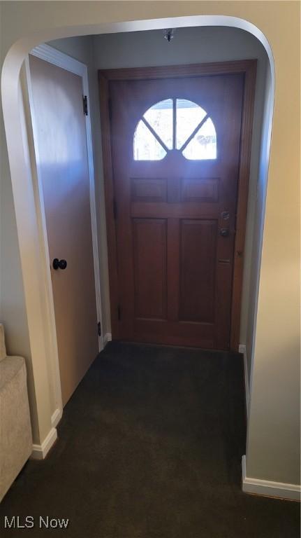 doorway to outside featuring dark colored carpet