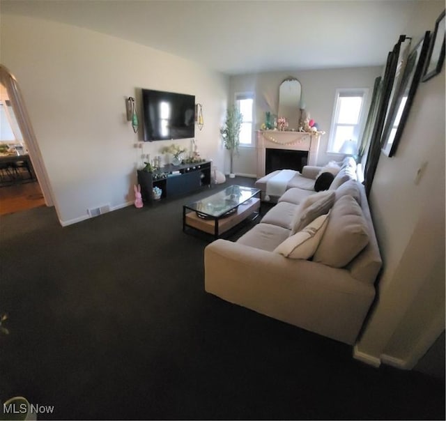 living room with visible vents, carpet flooring, a fireplace, and baseboards