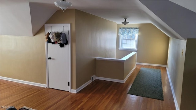 additional living space featuring vaulted ceiling, wood finished floors, and baseboards