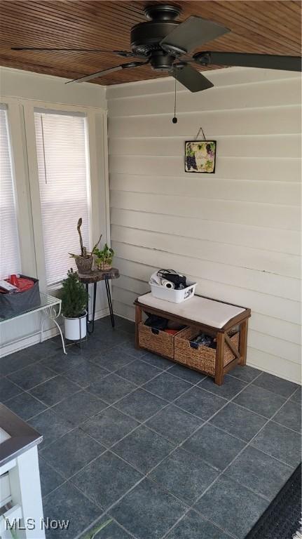 mudroom featuring wood walls and ceiling fan