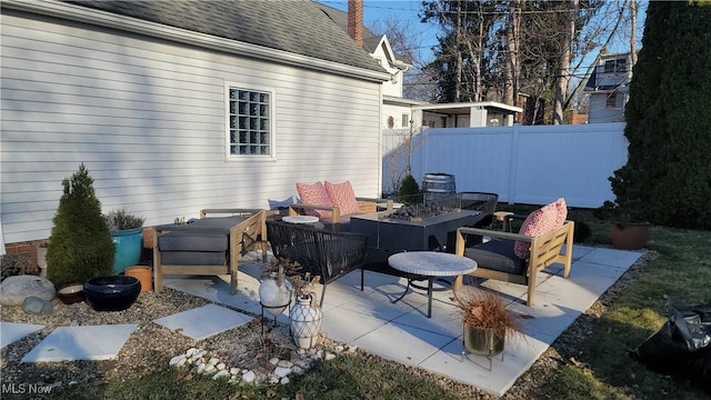 view of patio with an outdoor living space with a fire pit and fence